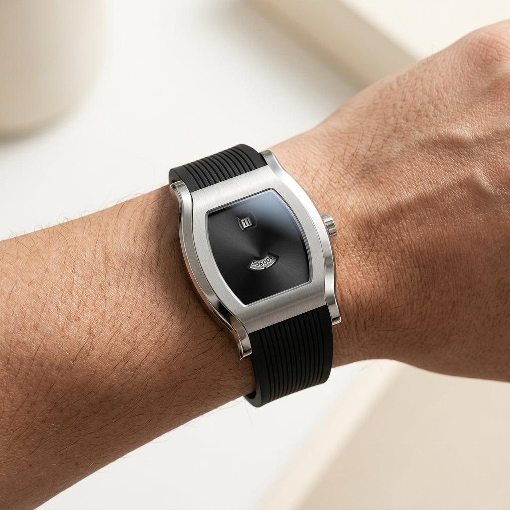 Black wristwatch with silver case on a person's wrist against a neutral background