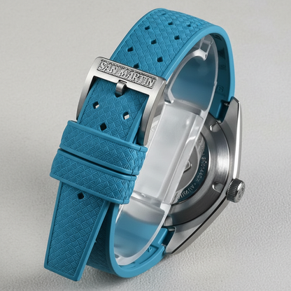 Blue watch with textured strap on a light gray background