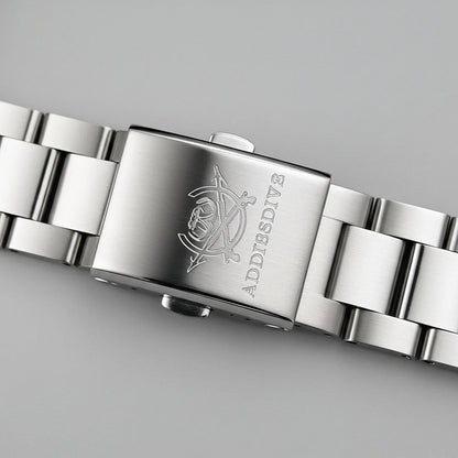 Close-up of a silver watch band with 'ADDIESDVE' branding on a gray background