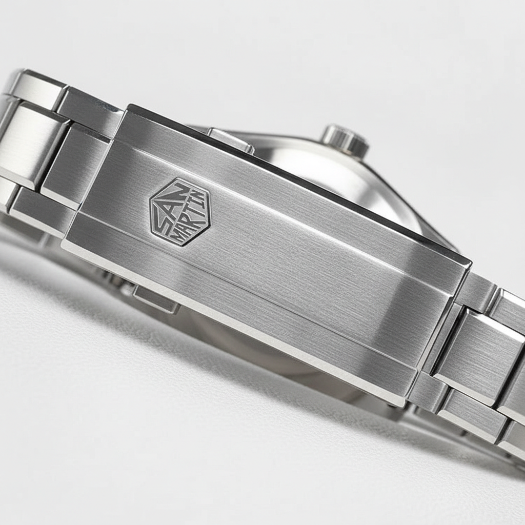 Close-up of a silver watch band with a brand logo on a light gray background