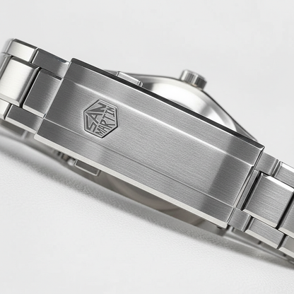 Close-up of a silver watch band with a brand logo on a light gray background