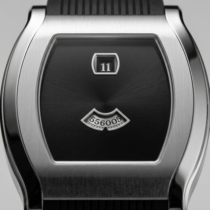 Close-up of a silver watch with a black face and date display on a gray background