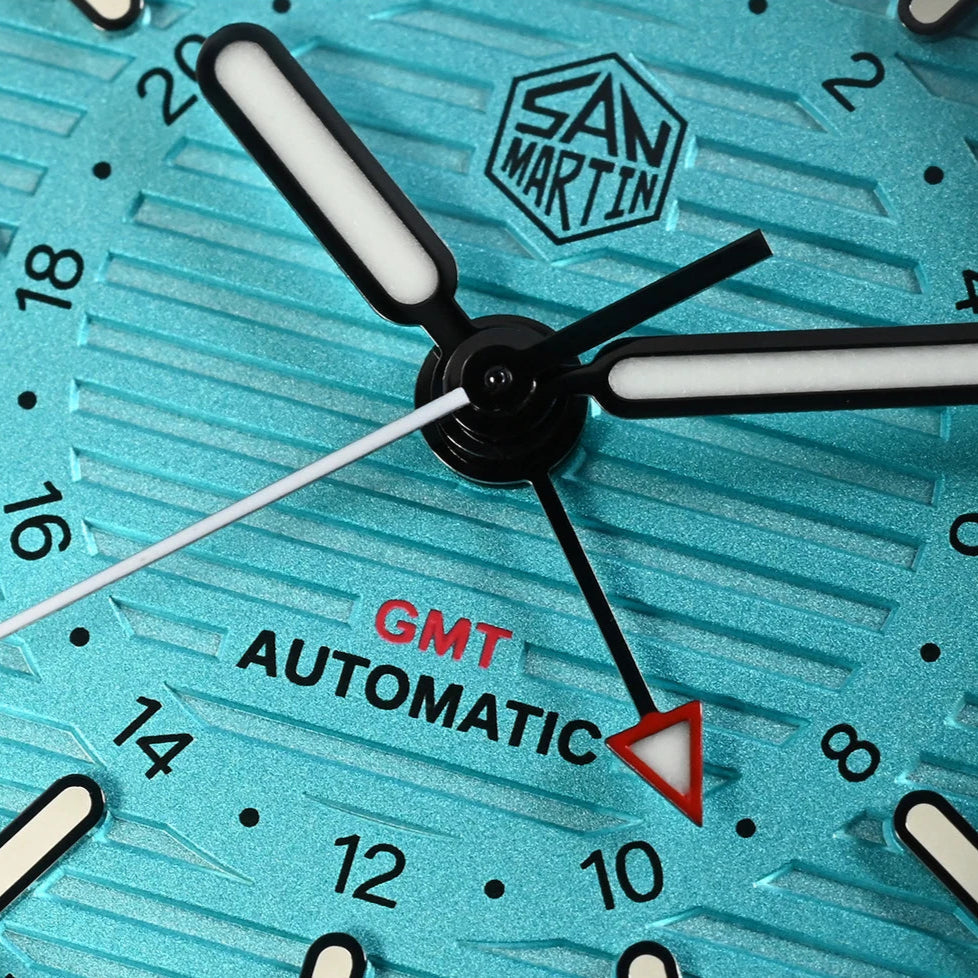 San Martin SN0075-G-C – Automatic Dive Watch – Macro Shot Showing GMT Automatic Text and Luminous Hands on Turquoise Dial