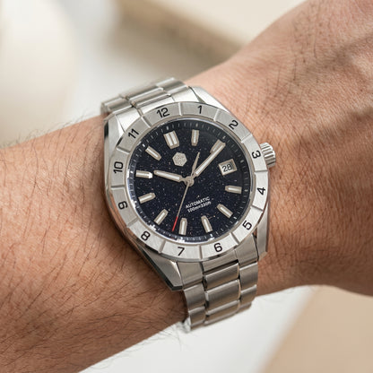 San Martin SN0130GB - Silver wristwatch with a dark face on a wrist against a neutral background