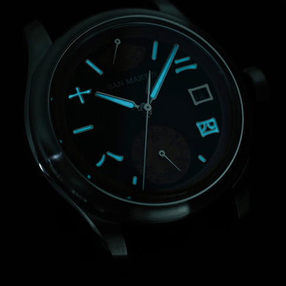 Luminous blue glow of San Martin SN0144-DG automatic mechanical watch hands and indices in darkness