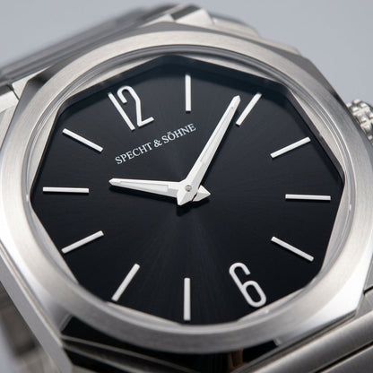Silver watch with black dial and 'SPECHT & SÖHNE' branding on a light gray background