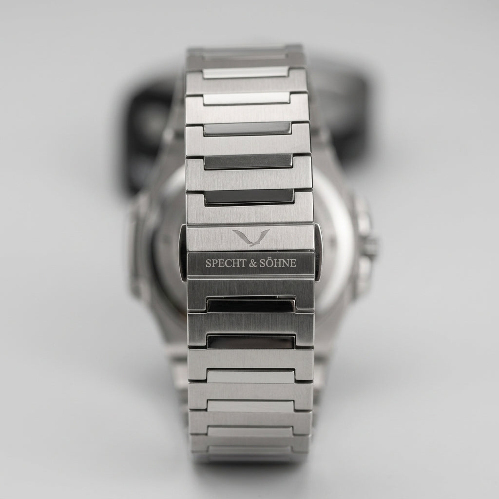 Silver watch with visible brand name on a light gray background