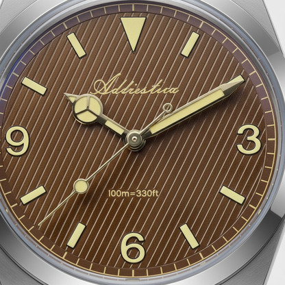Watch face with brown dial, gold hands, and 'Adherents' brand name.