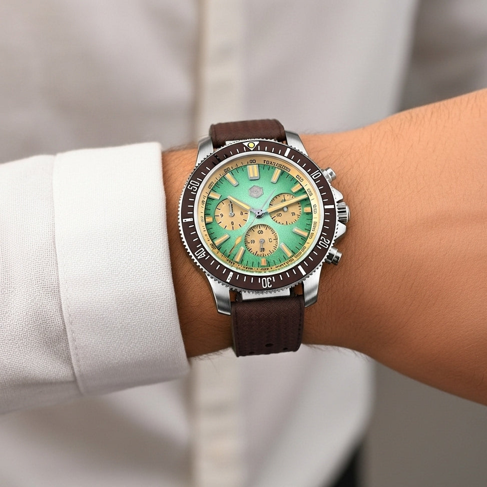 Watch with a green face and brown leather strap on a wrist.