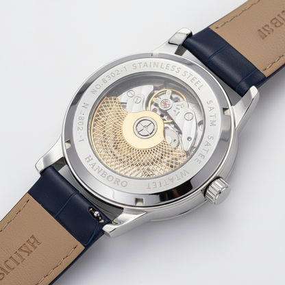 Watch with blue strap and visible mechanical components on a light gray background