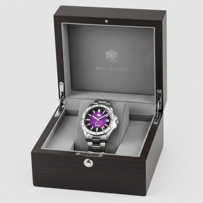 Watch with purple face and silver case in an open wooden box on a light gray background
