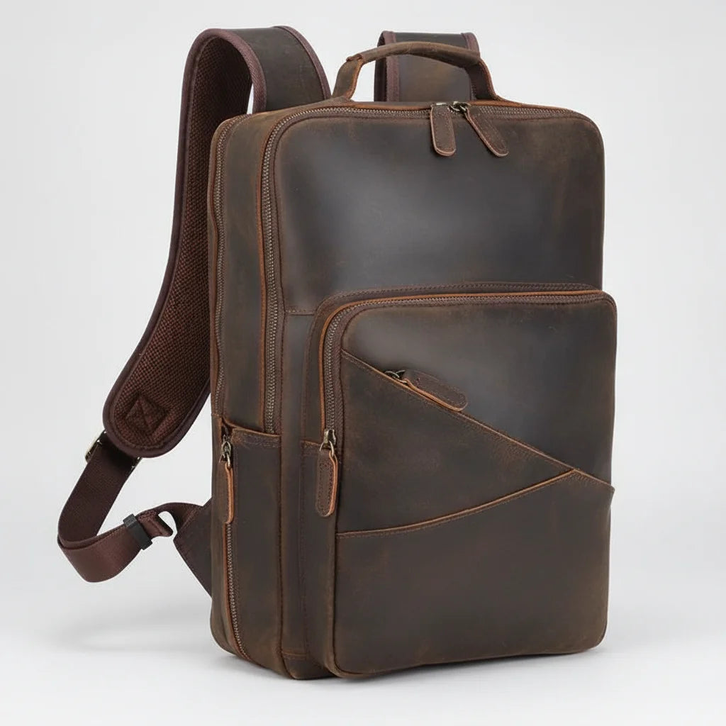 Men's Leather Travel Laptop Backpack — three-quarter view with front pocket and padded shoulder strap