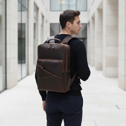 Men's Leather Travel Laptop Backpack — worn on the back by a man in a black sweater