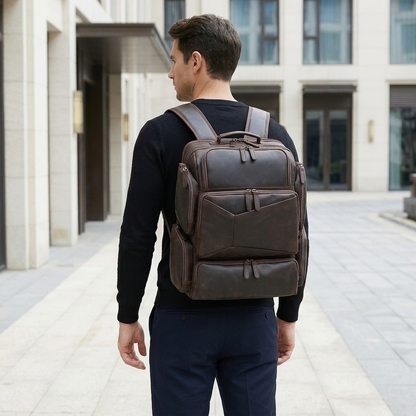 Men's Full-Grain Leather Large Travel Backpack with Luggage Sleeve — worn on the back by a man in a black knit shirt, rear view