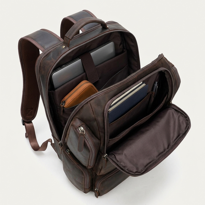 Men's Full-Grain Leather Large Travel Backpack with Luggage Sleeve — open with a laptop, notebooks, a pouch and a pen inside