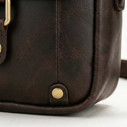 Men's Full-Grain Leather Mini Messenger Bag with Top Handle — close-up of the leather corner and stitching