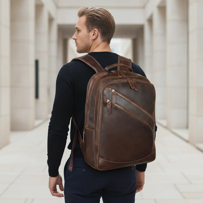 Leather Multi-Pocket Travel Backpack — worn on the back by a man in a black sweater