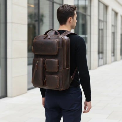 Vintage Leather Laptop Backpack — worn on the back by a man in a black sweater